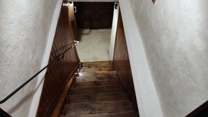 A wooden staircase with white walls and a door at the top.