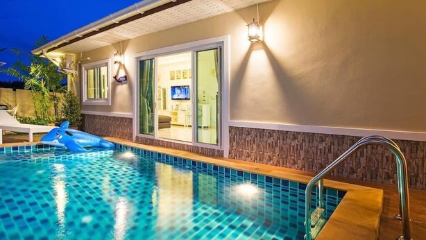 A swimming pool with a blue shark float, a covered patio, and a television in the background. - Aonang Sweet Blue Sea (Krabi)
