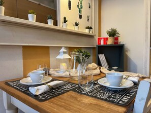 A neatly set dining table with placemats, cups, and a candle. - Minerva House - Two Bedroom Apartment, Sleeps 4 (Arezzo)