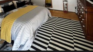 A bedroom with a bed, wooden beams, a black and white striped rug, a dresser, and a framed picture on the wall. - The Old Hanging Gate Inn built in the early 1800s as a former coach house inn. (Telford)