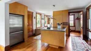 Una cocina moderna con armarios de madera, un refrigerador de acero inoxidable y una isla central.
