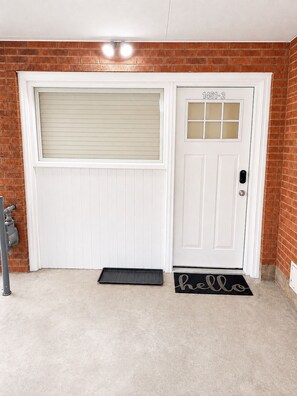 A white garage door with a number plate, a doormat with 'hello' written on it, and a metal pipe on the left. - Walk to BYU Stadium - 1BR Guest House + Parking (Provo)