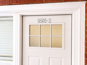 A white door with a six-pane window and the number '1451-2' above it.