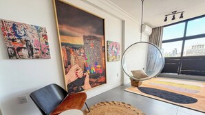 Ein modernes Wohnzimmer mit einem großen Gemälde, einem runden Spiegel und einem runden Teppich.