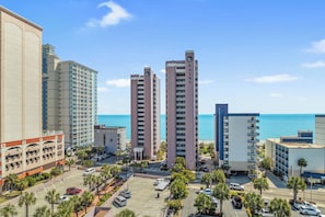 A high-rise hotel with multiple floors, a parking lot, and a view of the ocean. - Spacious 3-bedroom condo in Myrtle Beach with AC and ocean views 6th floor (Myrtle Beach)