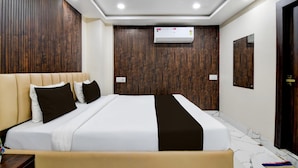 A modern hotel room with a large bed, wooden panel walls, an air conditioning unit, and a marble floor. - Hotel O Barasat Government College (Barasat)