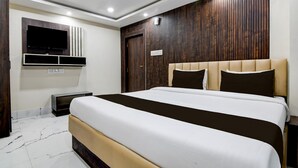A modern bedroom with a large bed, built-in TV, and a wooden panel wall. - Hotel O Barasat Government College (Barasat)