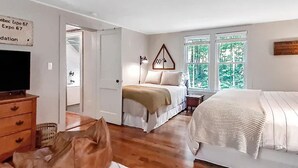 A bedroom with a bed, a desk, and a chair. There is a window with a view of trees. - Vermont Escape in Ludlow Village - Okemo (Ludlow)