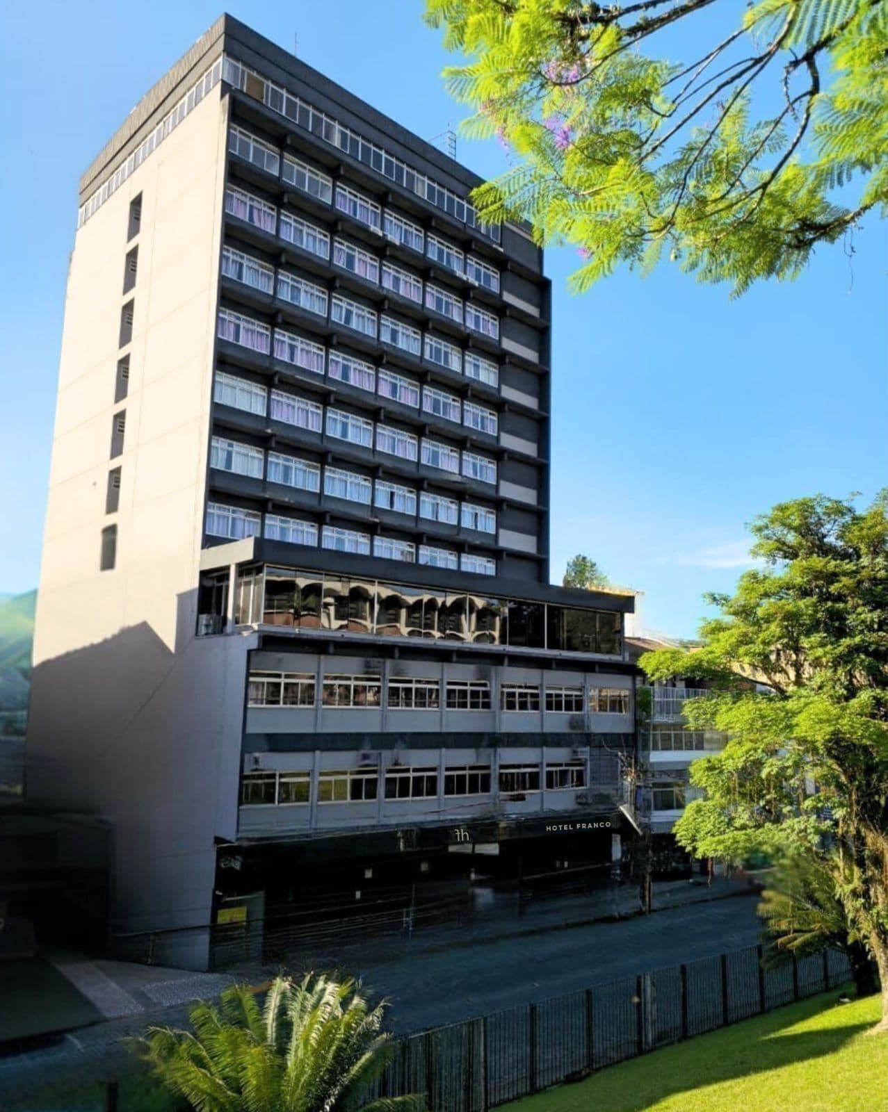 Un hotel de varios pisos con fachada plana, ventanas grandes y entrada a nivel de la calle.