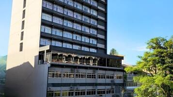 Un hotel de varios pisos con fachada plana, ventanas grandes y entrada a nivel de la calle.