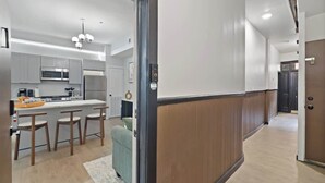 Une cuisine moderne dotée d’un îlot central, de tabourets de bar et d’un four à micro-ondes.