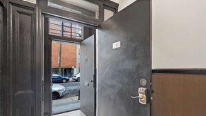 Une porte fermée, avec une plaque portant un numéro, une poignée en métal et un trou de serrure.
