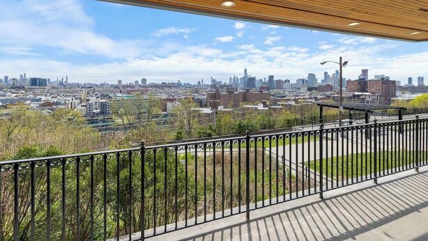 Blick von einem Balkon mit Stadtansicht im Hintergrund.