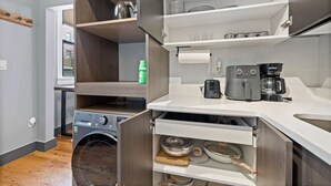 A compact kitchen with built-in appliances, including a washing machine, a coffee maker, and a toaster. - Modern Studio < 20 Min to NYC w/ Fast WiFi (Jersey City)