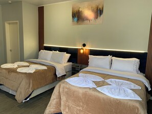 A hotel room with two beds, a painting on the wall, and a bedside lamp. - HG-101-Suite Inn (Vila Nova do Sul)