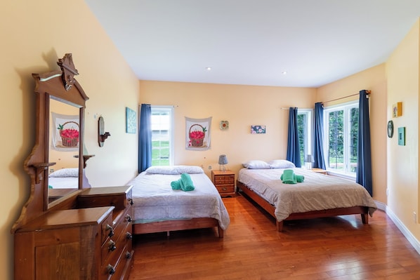 Een slaapkamer met twee bedden, houten meubels en een grote spiegel.