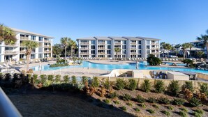 Ein Resort mit mehreren Gebäuden, einem großen Schwimmbad und Palmen.