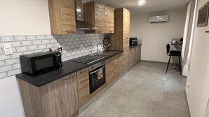 A modern kitchen with wooden cabinets, a black countertop, and a built-in oven.