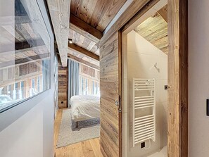 Ein Schlafzimmer mit Bett, Holzboden, Fenster und Heizkörper.