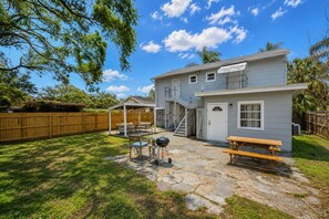 A two-story house with a patio, outdoor seating, and a barbecue grill. - Historic Uptown 2BD 1BA - 8 min to Downtown & Pier (St. Petersburg)