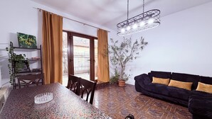A dining area with a patterned table, a black sofa, and a hanging light fixture. -  Accommodates up to 6 guests,Free parking,Near Amazonia Aquapark,Iulius Town (Timișoara)