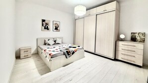 A modern bedroom with a bed, a wardrobe, a nightstand, and a ceiling light. -  Accommodates up to 6 guests,Free parking,Near Amazonia Aquapark,Iulius Town (Timișoara)