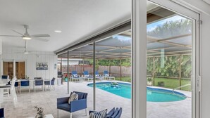 Un grand espace intérieur doté d’une piscine, de coins salon et d’une pancarte indiquant « BIENVENUE ».