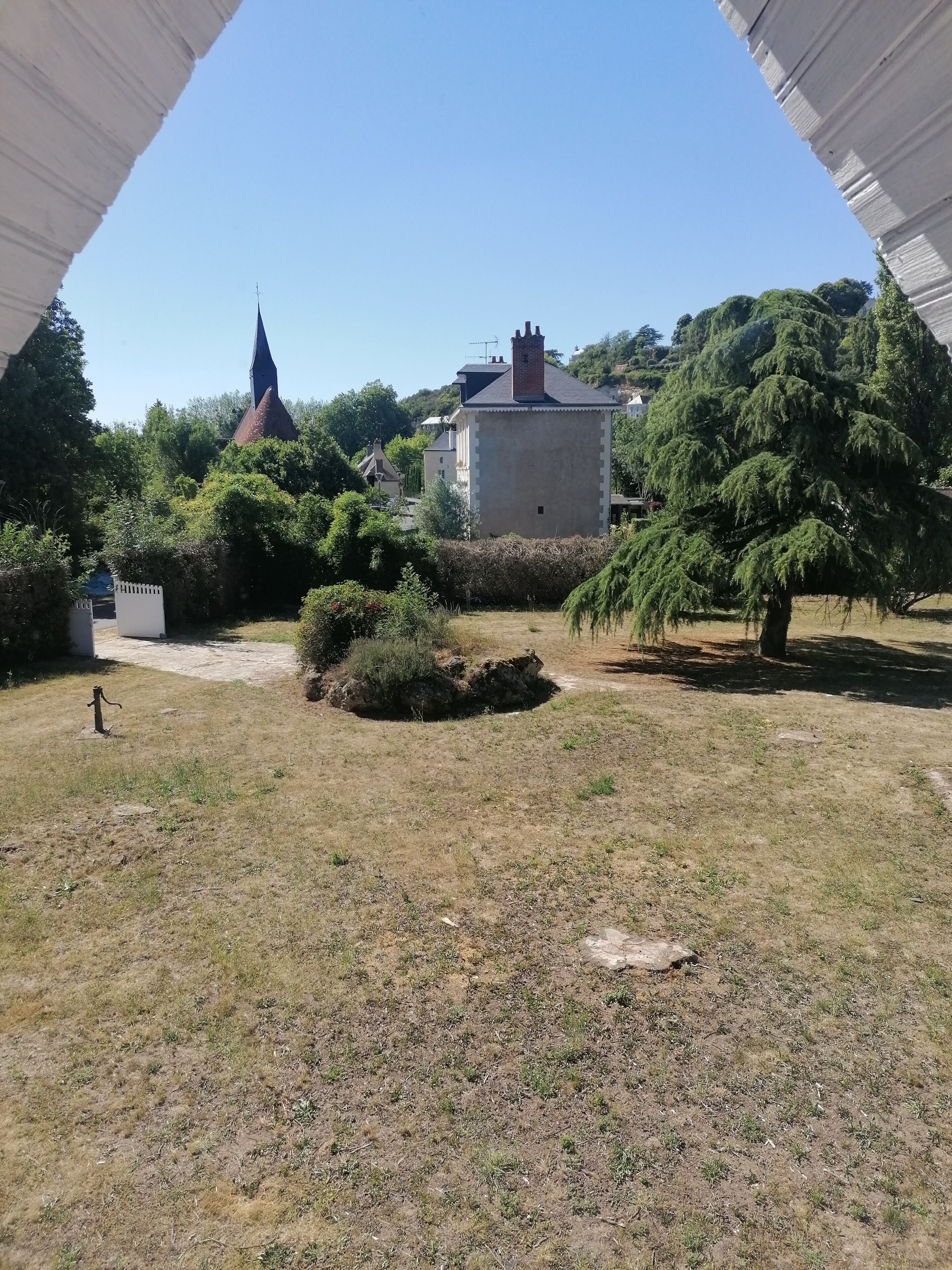 A courtyard with a building, trees, and a small garden area.