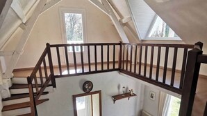 Une pièce de style loft avec un escalier en bois, un canapé et une table basse.