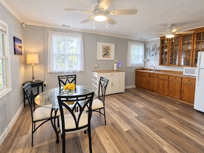 A kitchen with wooden cabinets, a round glass table, and chairs.