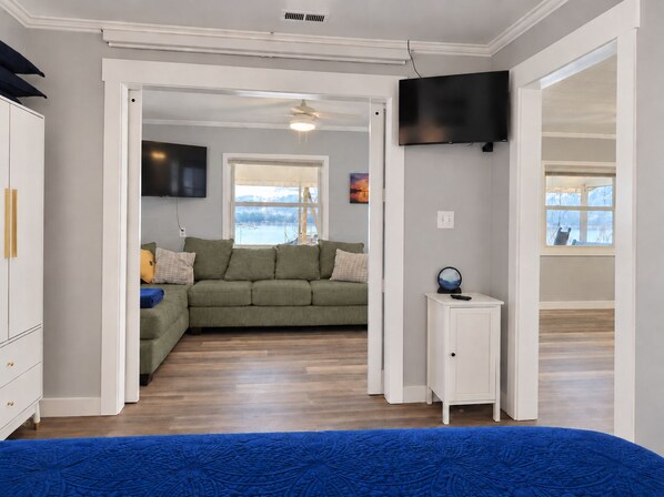 A room with a bed, a sofa, a TV, and a window with a view.