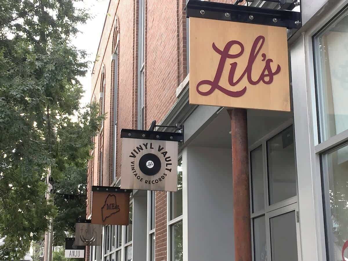 A building with a sign that reads "Lil's" and another sign for "Vinyl Vault."
