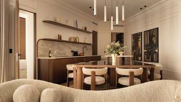 Una cocina moderna con encimera de mármol, armarios de madera y un comedor con una mesa redonda y sillas.