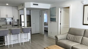A modern apartment with a kitchen, dining area, and living room. - Naples Pier Condo 123 (Naples)