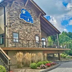 A building with a stone facade and a sign that reads "SuperSkies Country Club". - Ski In/Out Suite with a Loft, Pool, Gym (Sugar Mountain)