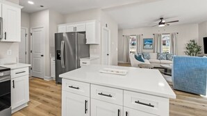 A modern kitchen with white cabinetry, a stainless steel refrigerator, and a central island. - New Build close to HPU, Furniture Mrkt & Downtown (High Point)