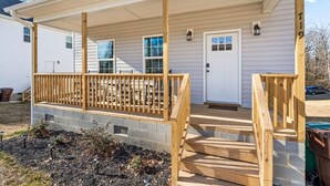 A two-story house with a covered porch and a front door. - New Build close to HPU, Furniture Mrkt & Downtown (High Point)