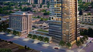 Een modern hoog gebouw met meerdere verdiepingen, grote ramen en een opvallende glazen gevel.