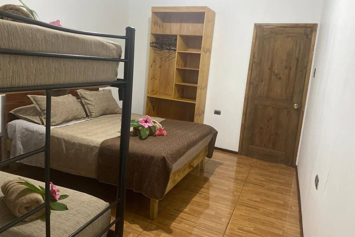 A room with a bunk bed, a wooden wardrobe, and a door.