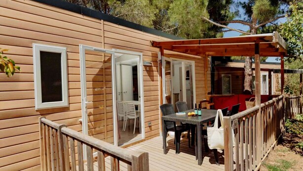 A wooden cabin with a deck, a covered outdoor seating area, and a visible door leading to a room. - Modern Holiday Home in Sant Salvador (El Vendrell)