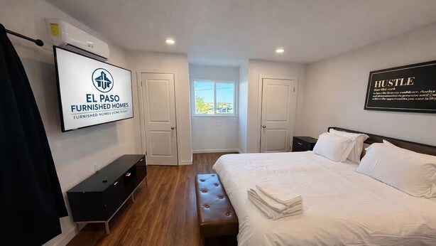 A furnished bedroom with a bed, a bench, a TV, and a motivational quote on the wall. - Cozy Remodel 2 Story w/ King Bed / W/D / BBQ Patio (El Paso)