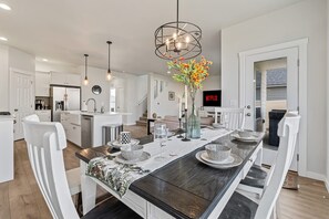Una cocina moderna con armarios blancos, una isla central e iluminación colgante.