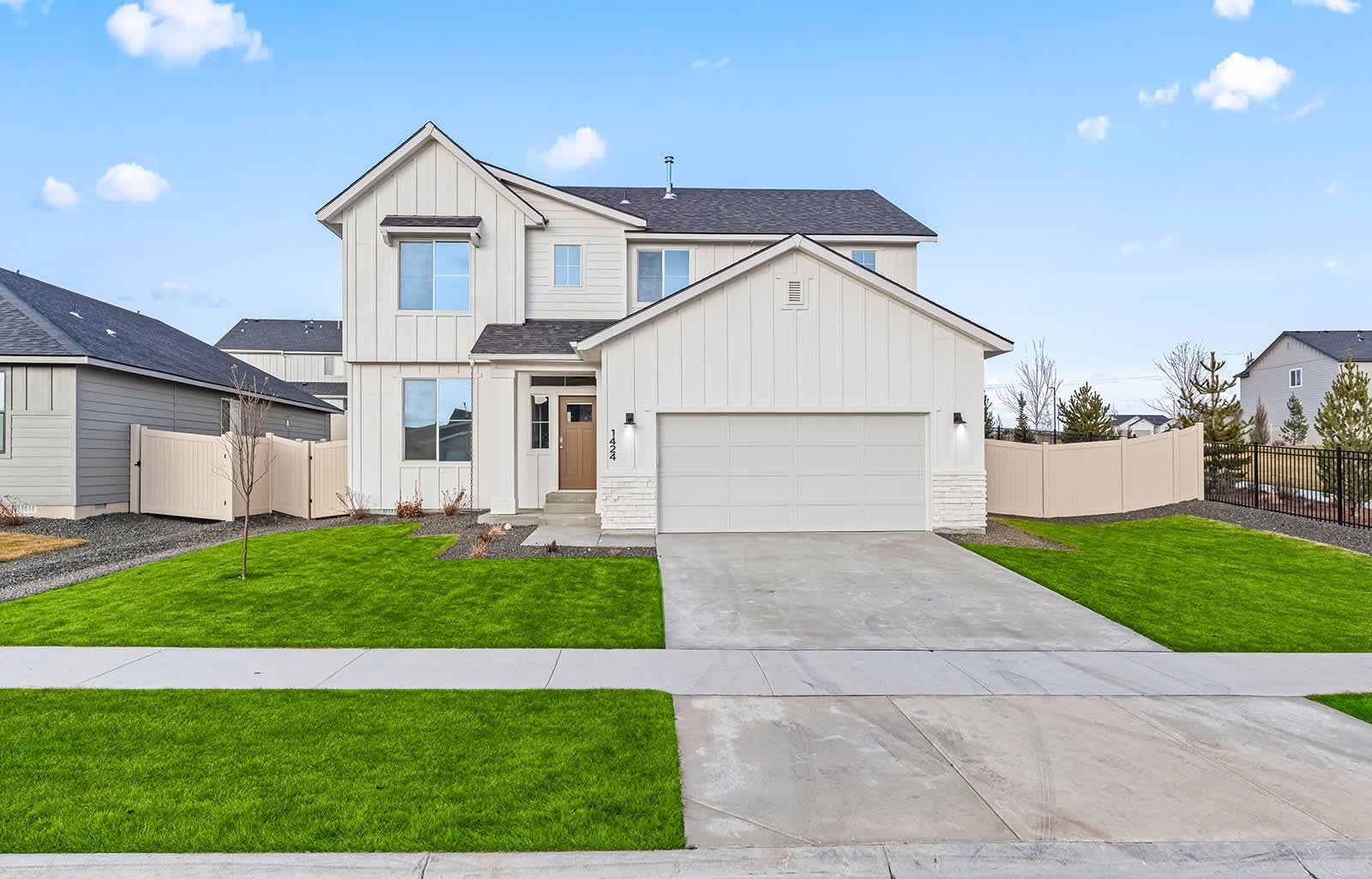 A two-story house with a garage, a front lawn, and a driveway.