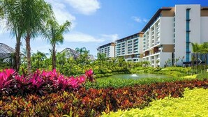 A resort with modern buildings, a landscaped garden with colorful plants, and a small pond. - LUXURY Vidanta Nuevo Vallarta Grand Luxxe 2 Bedroom Villa (Las Jarretaderas)