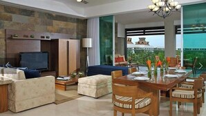 A modern living room with a sofa, ottoman, and a dining table set for four. - LUXURY Vidanta Nuevo Vallarta Grand Luxxe 2 Bedroom Villa (Las Jarretaderas)