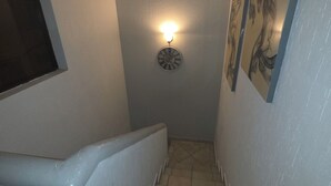 A narrow stairway with a wall-mounted clock and a light fixture. - 3-bedroom townhome in beautiful Puerto Peñasco with AC blocks from beach. (Puerto Peñasco)