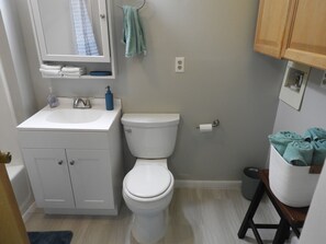 A bathroom with a white sink, a toilet, and a mirror.
