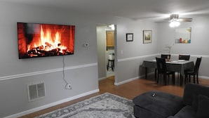 Ein Wohnzimmer mit Kamin, Essbereich und Deckenventilator.