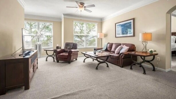 A living room with a ceiling fan, a sofa, two armchairs, a coffee table, a TV stand, and a lamp. - this is very basic. (Jacksonville)