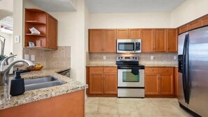 A kitchen with wooden cabinets, a stainless steel refrigerator, a microwave, and a double oven. - this is very basic. (Jacksonville)